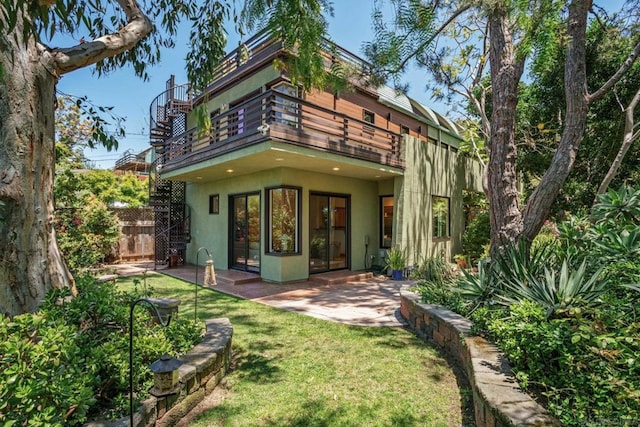 back of house featuring a yard, a patio, and a balcony