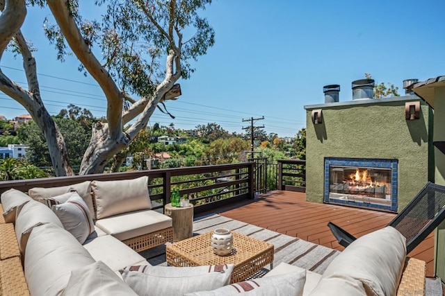 wooden deck featuring an outdoor living space with a fireplace