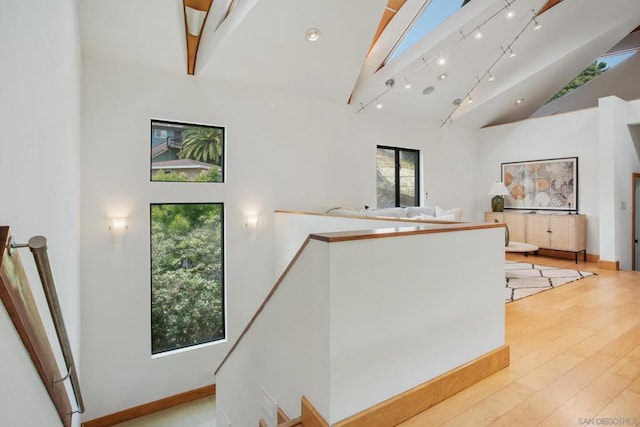 interior space with hardwood / wood-style flooring, track lighting, and high vaulted ceiling