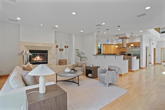 living room with light hardwood / wood-style flooring and a fireplace