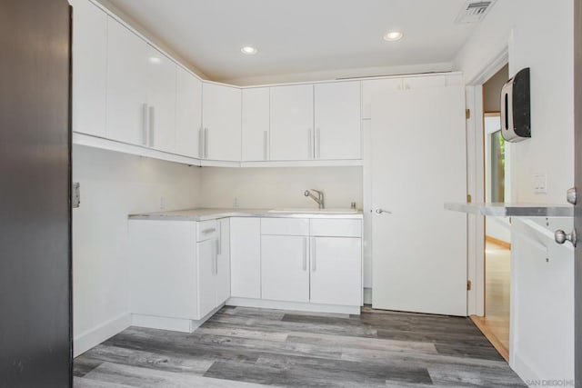 kitchen with white cabinetry, sink, and dark wood-type flooring