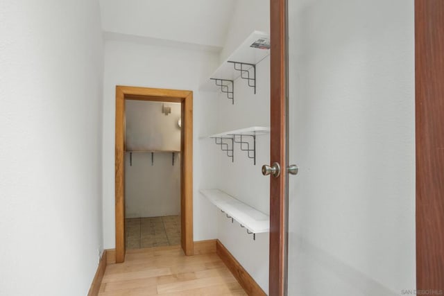 walk in closet with light hardwood / wood-style flooring