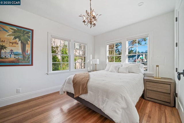 bedroom featuring an inviting chandelier and hardwood / wood-style flooring