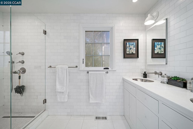 bathroom featuring tile walls, tile patterned floors, vanity, and a shower with shower door