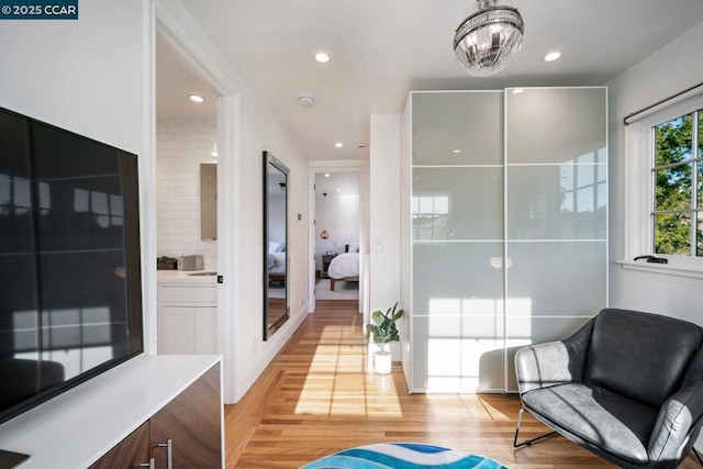 sitting room featuring a chandelier and light hardwood / wood-style floors