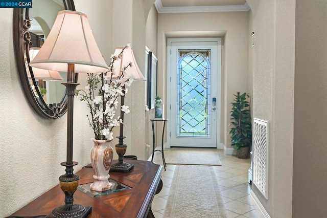 tiled foyer entrance with crown molding