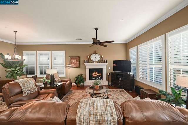 living room featuring crown molding, wood-type flooring, and ceiling fan with notable chandelier