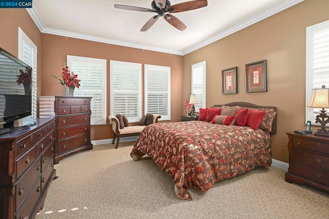 carpeted bedroom featuring ceiling fan and crown molding