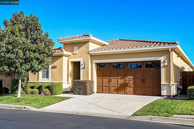 mediterranean / spanish-style home with a front yard and a garage