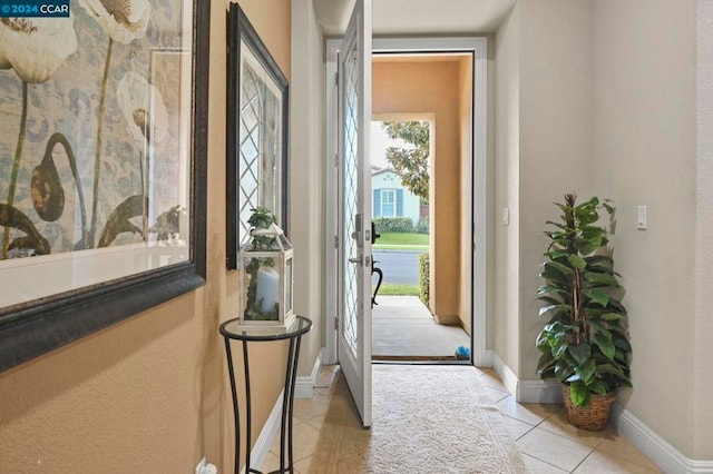 doorway to outside with light tile patterned floors