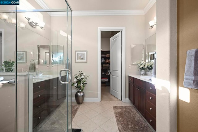 bathroom featuring a shower with door, vanity, crown molding, and tile patterned flooring