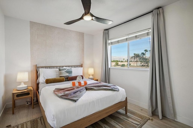 bedroom with light hardwood / wood-style floors and ceiling fan