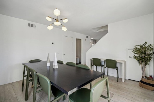 dining space with a chandelier and light hardwood / wood-style flooring