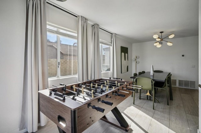 playroom with a chandelier and light hardwood / wood-style flooring