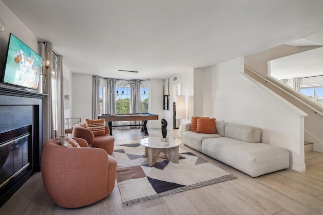 living room with light hardwood / wood-style floors, a healthy amount of sunlight, and billiards