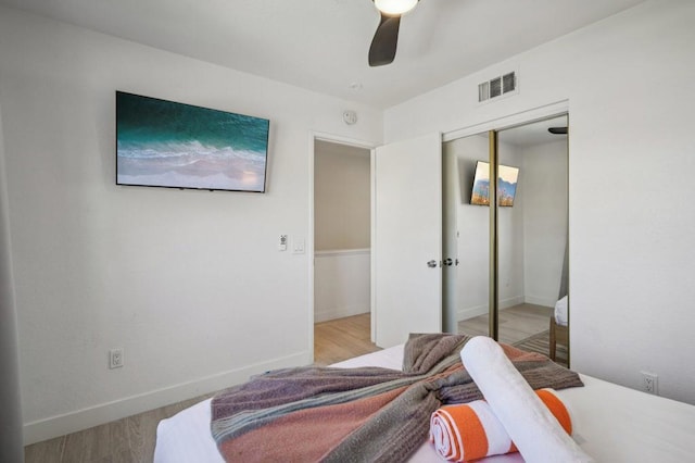 bedroom featuring ceiling fan, a closet, and light hardwood / wood-style floors