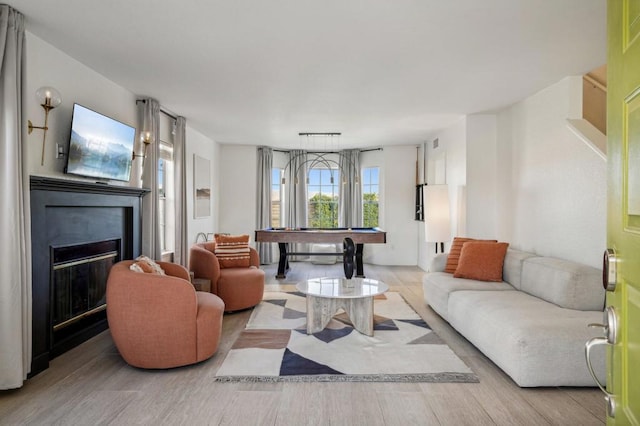 living room featuring light hardwood / wood-style floors and pool table