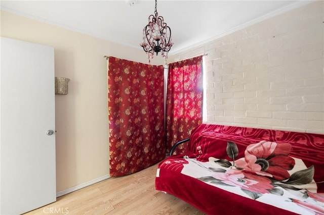 bedroom featuring wood-type flooring, crown molding, and brick wall