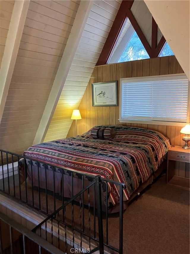 bedroom featuring vaulted ceiling with beams, wooden walls, and carpet