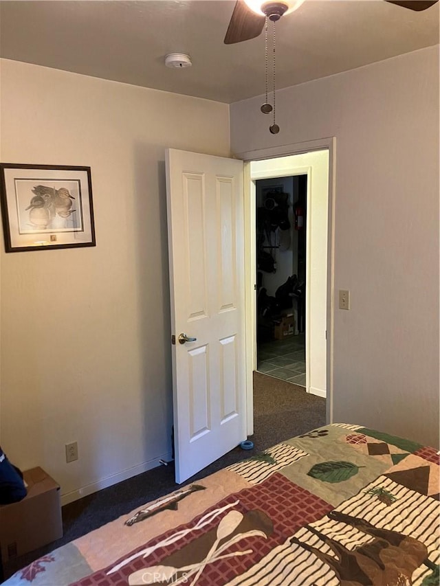 unfurnished bedroom featuring dark colored carpet and ceiling fan