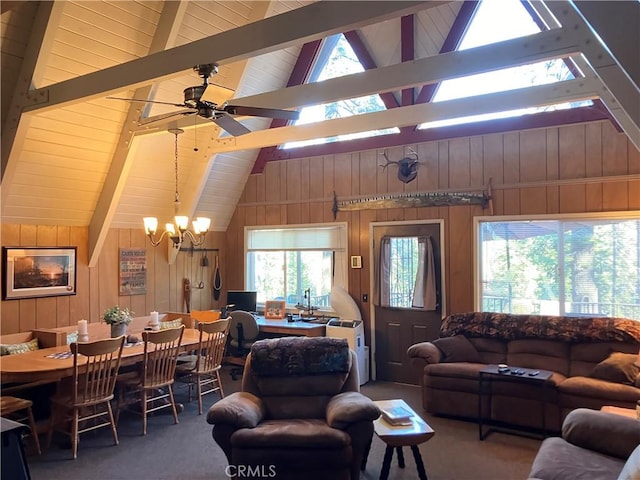 living room featuring beam ceiling, wood walls, high vaulted ceiling, and ceiling fan with notable chandelier