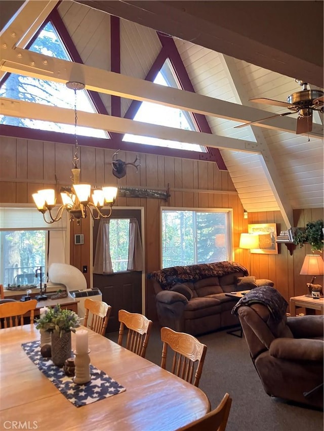 dining room with high vaulted ceiling, ceiling fan with notable chandelier, beam ceiling, and wooden walls