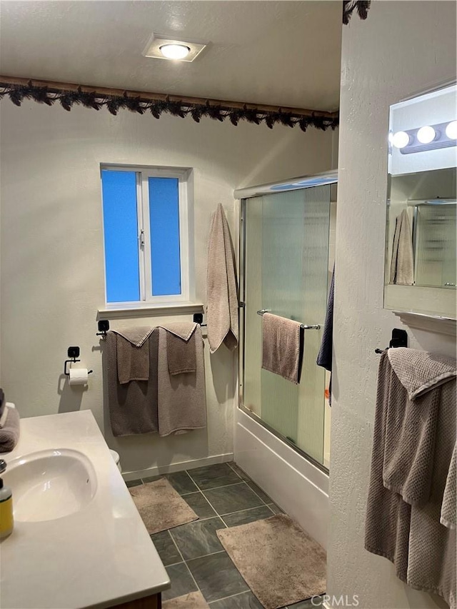 bathroom with vanity and enclosed tub / shower combo