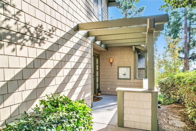 entrance to property featuring a patio area and a pergola