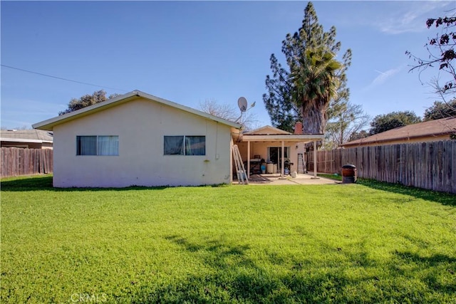 rear view of house with a lawn and a patio