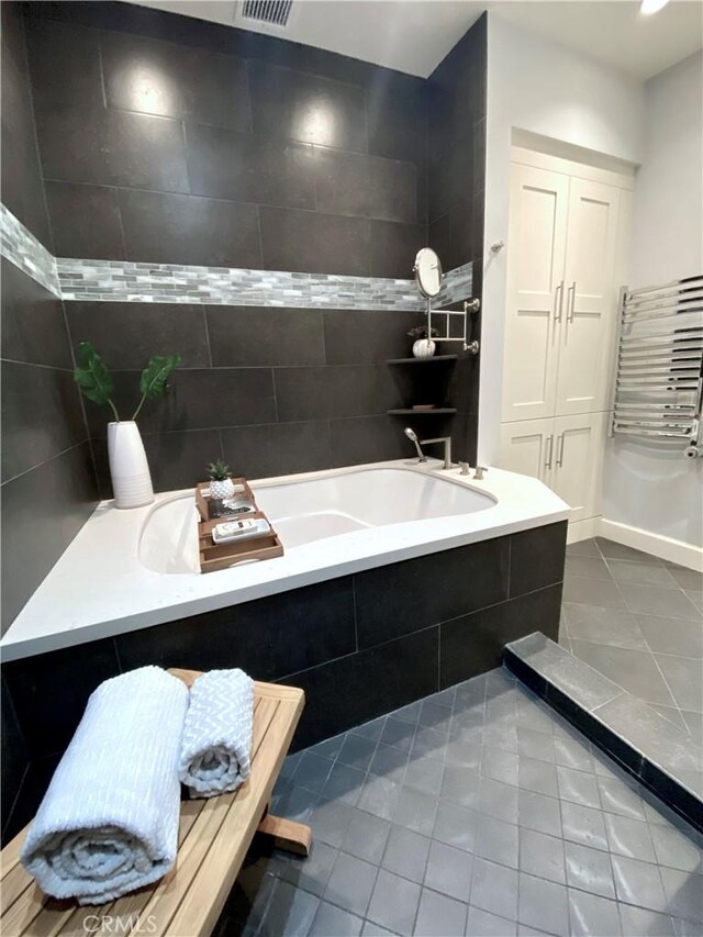 bathroom featuring tiled tub and tile patterned floors