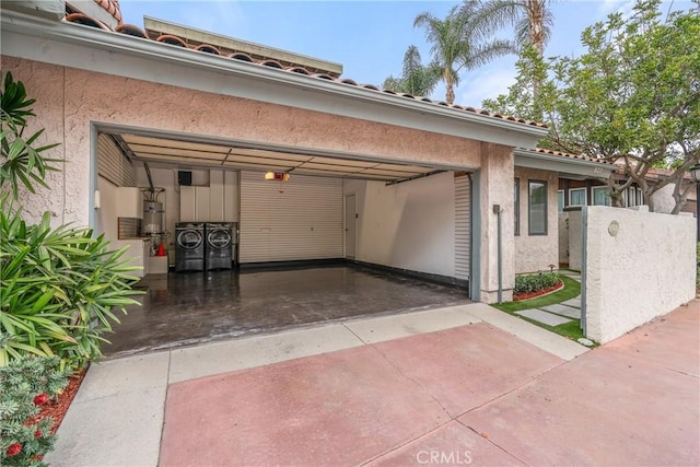 garage featuring water heater and washing machine and clothes dryer