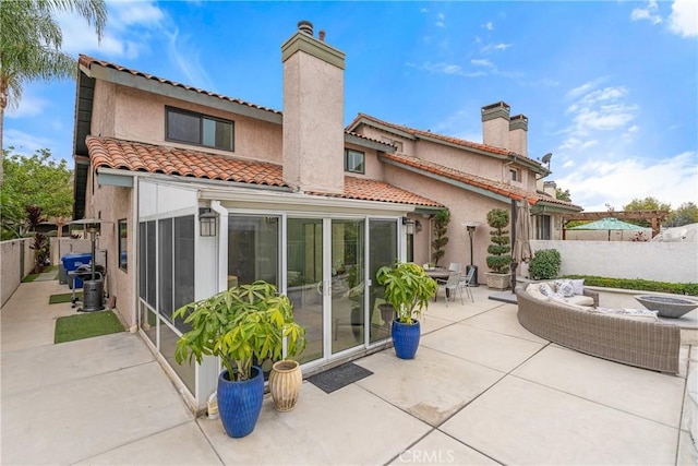 back of house with a sunroom and a patio