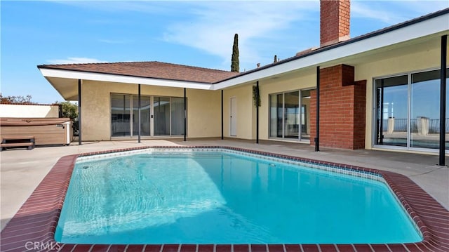 view of swimming pool featuring a patio area and a hot tub