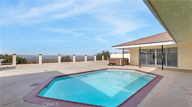 view of swimming pool with a patio area and a hot tub