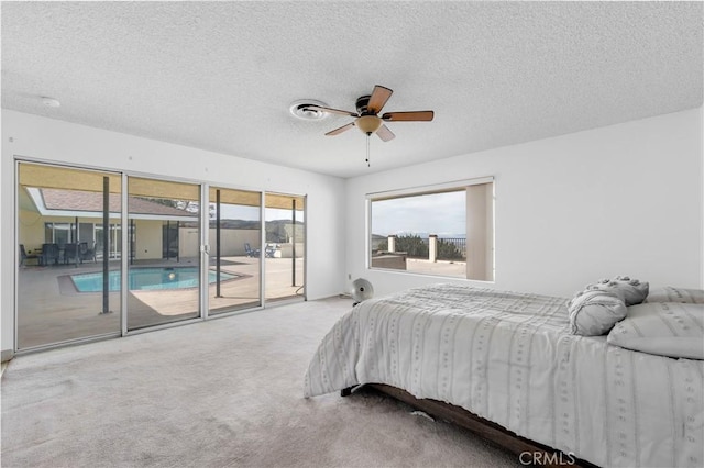 carpeted bedroom with access to exterior, ceiling fan, and a textured ceiling