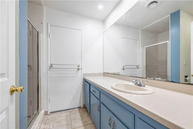 bathroom with tile patterned floors, vanity, and a shower with shower door