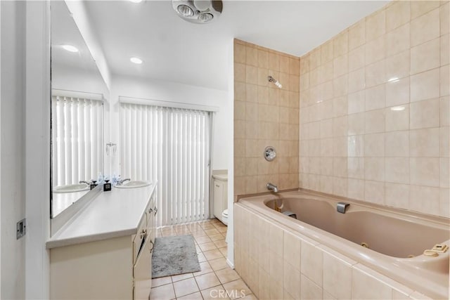 full bathroom featuring tile patterned flooring, vanity, tiled shower / bath combo, and toilet