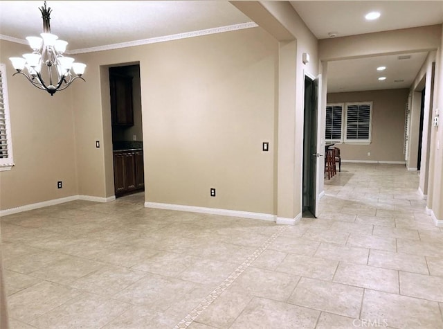 tiled empty room with a chandelier and crown molding