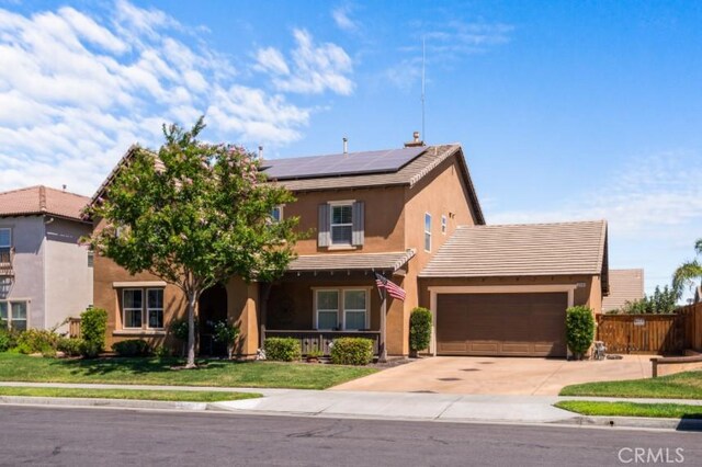 view of front of home with solar panels, a garage, and a front lawn