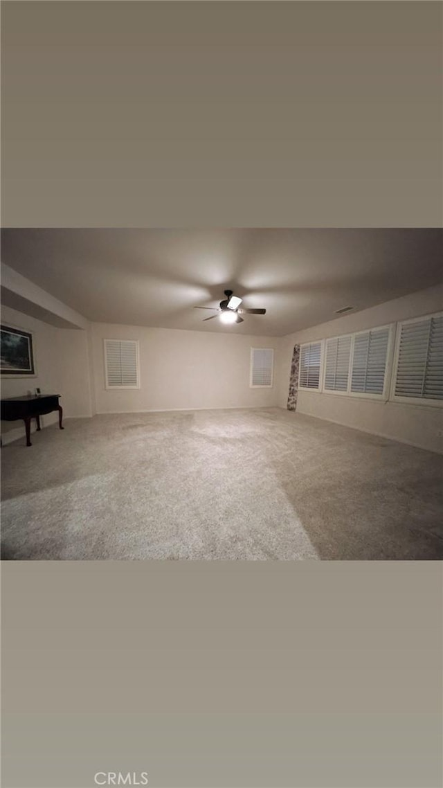 carpeted empty room featuring ceiling fan