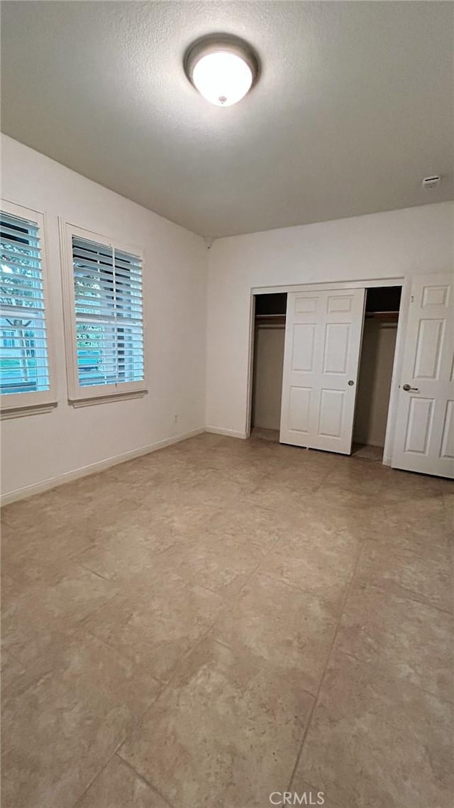 unfurnished bedroom with a textured ceiling and a closet