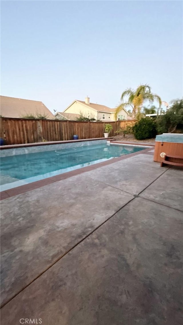 view of swimming pool with a patio and a hot tub