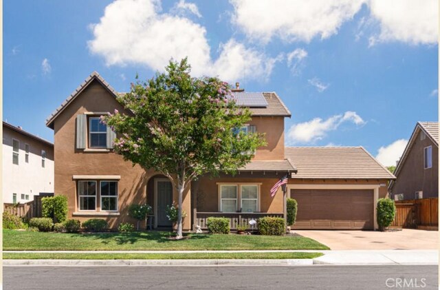 view of front of home with a garage, a front yard, and solar panels