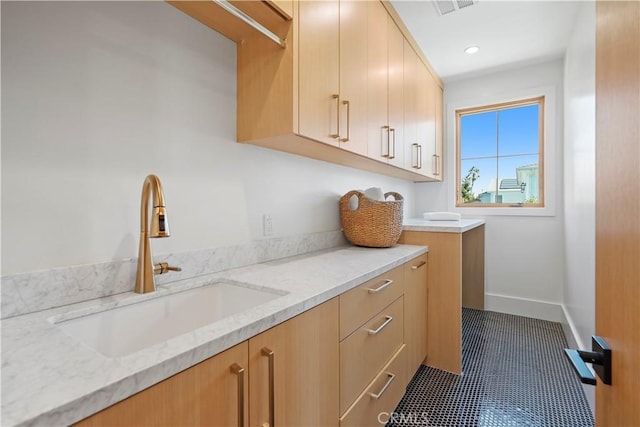 laundry area with sink and dark tile patterned floors