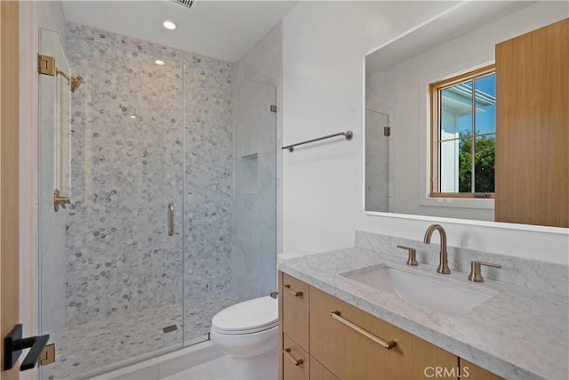 bathroom featuring tile patterned floors, vanity, toilet, and an enclosed shower