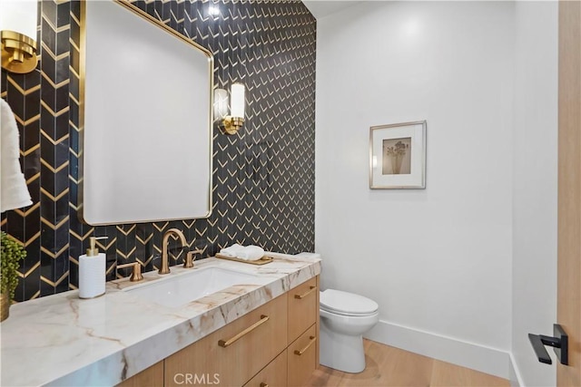 bathroom featuring wood-type flooring, vanity, and toilet