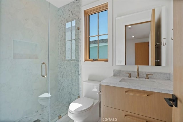 bathroom featuring walk in shower, vanity, and toilet