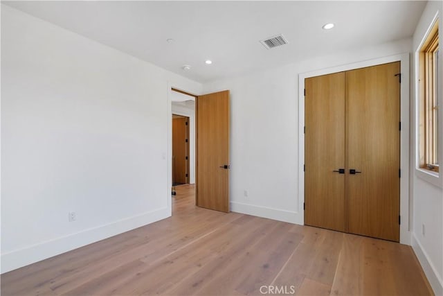 unfurnished bedroom featuring light hardwood / wood-style floors and a closet