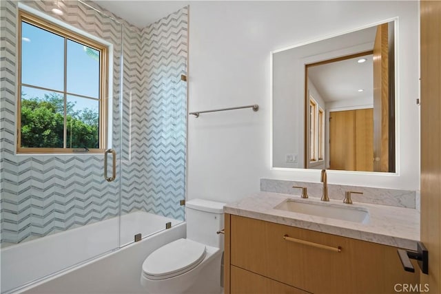 full bathroom featuring vanity, enclosed tub / shower combo, and toilet