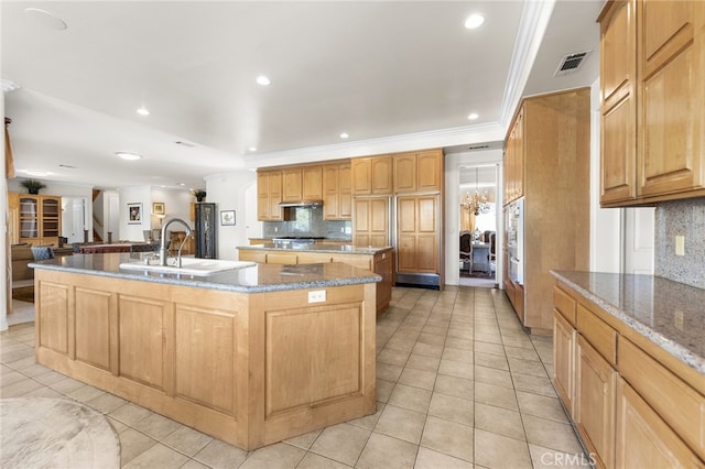 kitchen with decorative backsplash, a kitchen island with sink, and light tile patterned flooring